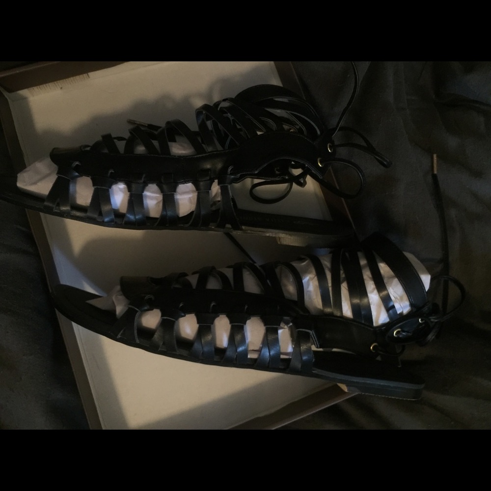 Black gladiator flat shoes.
